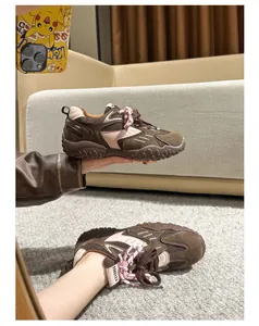Detalle de zapatillas retro con plataforma en gamuza marrón y cordones rosas