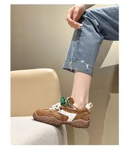 Vista lateral detallada de zapatillas de gamuza marrón con cordones verdes en modelo