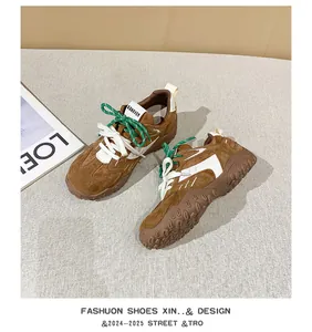 Detalle de zapatillas de ante marrón en contraste con sistema de cordones dobles