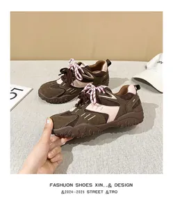 Detalle de zapatilla retro con plataforma de ante marrón cordones rosas y suela alta