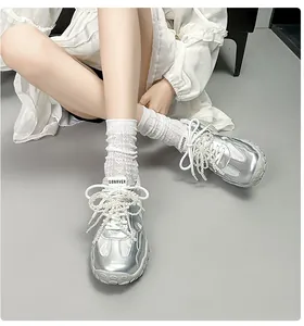 Detail silberner Metallic-Sneaker im Ballett-Stil mit eleganten Perlenketten und Plateausohle