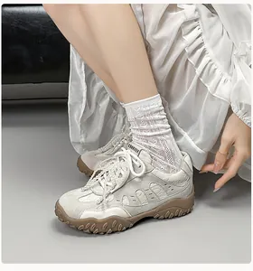 Details von beigen Leder-Sneakern mit Perlenkette und brauner Gummisohle für Damen