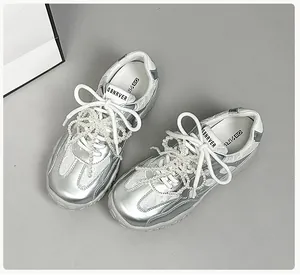 Detailansicht aus weißem Spitzenstoff und silbernem Metallic-Leder am Ballet-Sneaker
