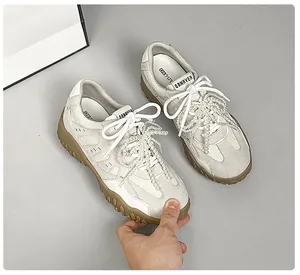 Nahaufnahme der Leder-Sneaker mit Perlenverzierung und Krokoprägung-Textur-Details