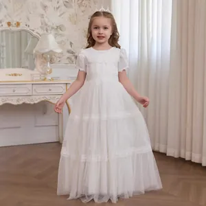 Detail of white girls lace gown showing puffy short sleeves and tiered mesh tulle layers