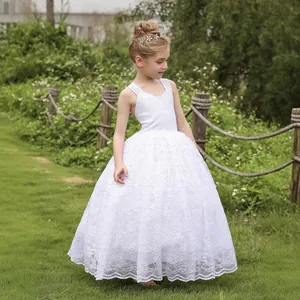 Detalle del elegante vestido de encaje blanco para niña con motivos florales y falda