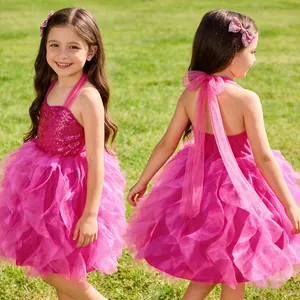 Detailed back view of girl's sequined dress featuring a large satin bow and layered tulle
