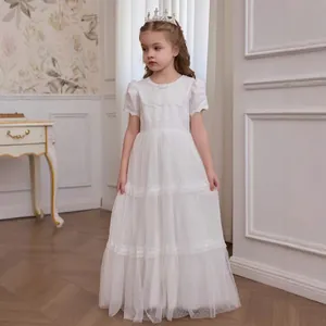 Detail of white layered tulle dress for girls featuring lace embroidery and polka dots