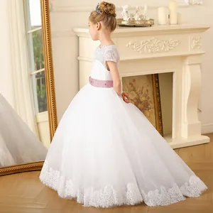 Dettaglio dell'abito da damigella in pizzo bianco con cintura in raso viola e gonna in tulle