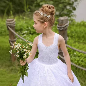 Primer plano de vestido de princesa con encaje blanco con tocado floral y flores silvestres