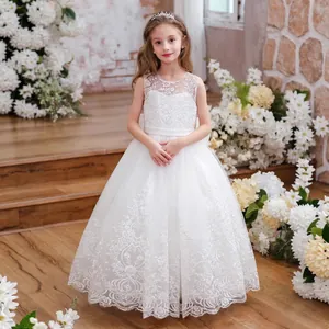 Detailed view of white floral lace embroidery and mesh layers on a girl's formal dress