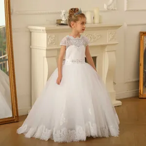 Dettaglio macro dell'orlo in tulle multistrato e ricami in pizzo sull'abito da bambina