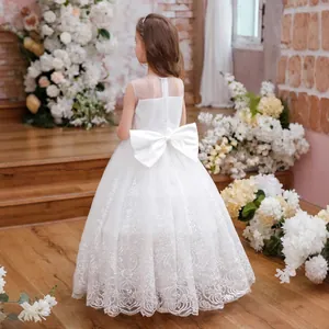 Close-up of white girls' formal dress featuring a large satin bow and lace embroidery