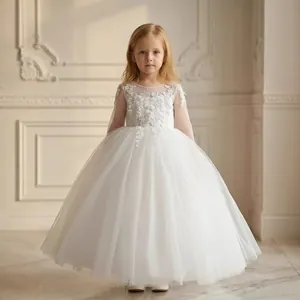 Dettaglio del ricamo in pizzo floreale e strati di tulle sul vestito bianco da ragazza