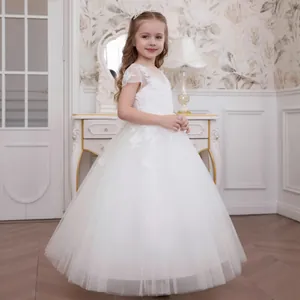 Close-up of white lace floral appliqués and mesh fabric on a girl's princess dress