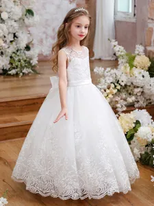 Detail of white lace flower embroidery and layered tulle on the girl's wedding dress