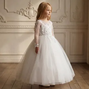 Dettagli di ricamo in pizzo bianco e maniche in tulle su un abito da damigella per bambina