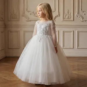 Dettaglio di ricamo in pizzo su maniche e corpetto dell'abito da damigella bianco per bambina