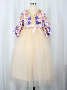Detailed embroidery on V-neck bodice with floral prints and apricot tulle skirt layers
