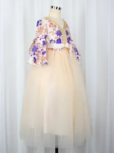 Detail of floral printed top and layered champagne tulle skirt with gold sequin trim