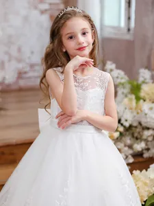 Elegant sleeveless white lace flower girl dress with a large bow and puffy mesh skirt