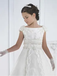 Elegant white lace flower girl dress with puff sleeves and bow, including accessories