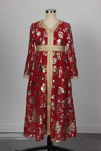 Detalle de bordados dorados y flores rosas en un vestido kaftán rojo para niñas