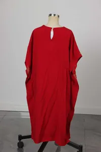 Dettaglio dell'abito etnico rosso da bambina con ricamo dorato e bottone a perla