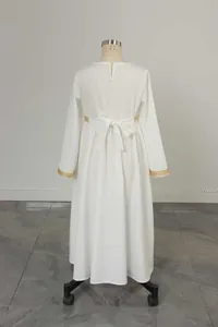 Detail of white girls' dress featuring golden lace trim on sleeves and back waist tie