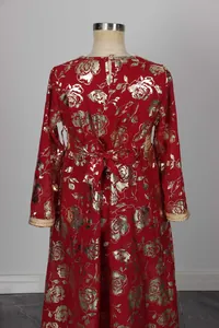 Detalle del vestido rojo con estampados de rosas doradas y lazo en la espalda