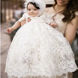Detalle de vestido de bautizo para bebé con encaje floral y gorro a juego incluido