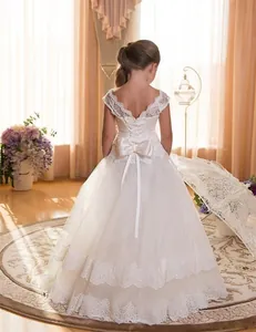 Detail of white lace flower girl dress featuring back cross-straps and a large satin bow