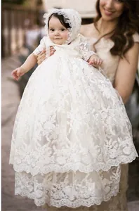 Detalle del vestido de bautizo blanco de encaje con bordados elegantes y gorro a juego