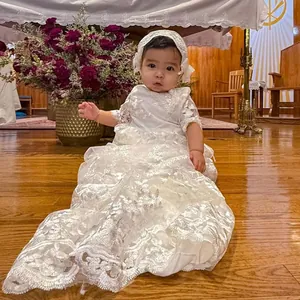Detalle del vestido de bautizo para bebé con falda de encaje a capas y bordado floral