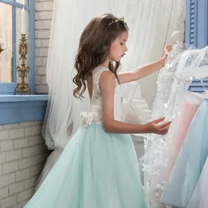 Primer plano del corpiño de encaje blanco delicado y espalda calada del vestido de niña