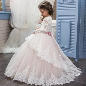 Details von eleganten Spitzenärmeln und Tüllschichten an einem Blumenmädchen-Hochzeitskleid