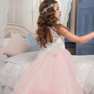 Pink tulle flower girl dress with white lace bodice and large back bow for weddings