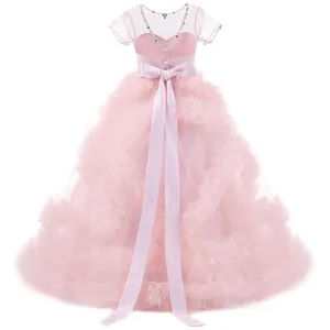 Pink flower girl dress detail featuring a satin waist belt and tiered lace mesh skirt