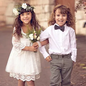 Detailed white lace embroidery on children's formal gown with floral headband accessory