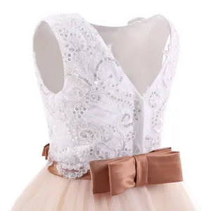 Detail of white lace bodice with sequins and a large champagne satin bow on the back
