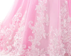 Détail du tulle rose multicouche et de la broderie florale blanche sur la robe fille