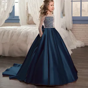 Dettaglio dell'abito da damigella in raso blu navy con maniche in pizzo e strascico elegante