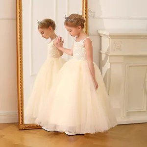 Nahaufnahme von Blumenstickerei und Tüllschichten an einem champagnerfarbenen Kleid