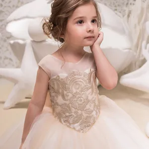 Detalle del bordado floral dorado y tul multicapa en el vestido de fiesta beige para niñas