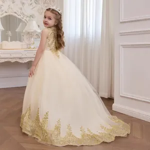 Detail of champagne flower girl dress showing golden lace embroidery and tulle tail