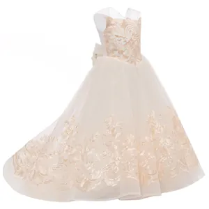 Detalle de bordados florales y encaje en el vestido de damita de honor champán