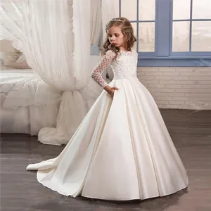 Detailed view of ivory satin flower girl dress featuring intricate lace sleeves and floral appliques