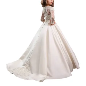 Detail of elegant white lace sleeves and back buttons on a satin flower girl gown
