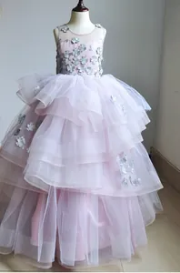 Dettagli di applicazioni floreali argentate e tulle a strati su abito rosa da principessa