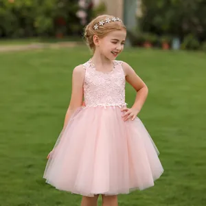 Close-up of pink flower girl dress featuring intricate lace bodice and layered tulle skirt